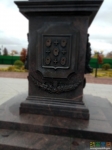 Герб города Козельск на барельефе стелы.